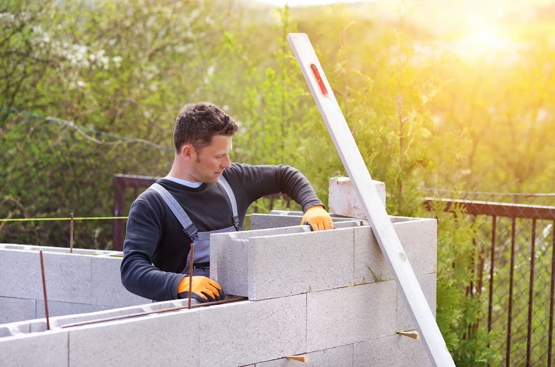 mason levelling a block retaining wall at a Boston property