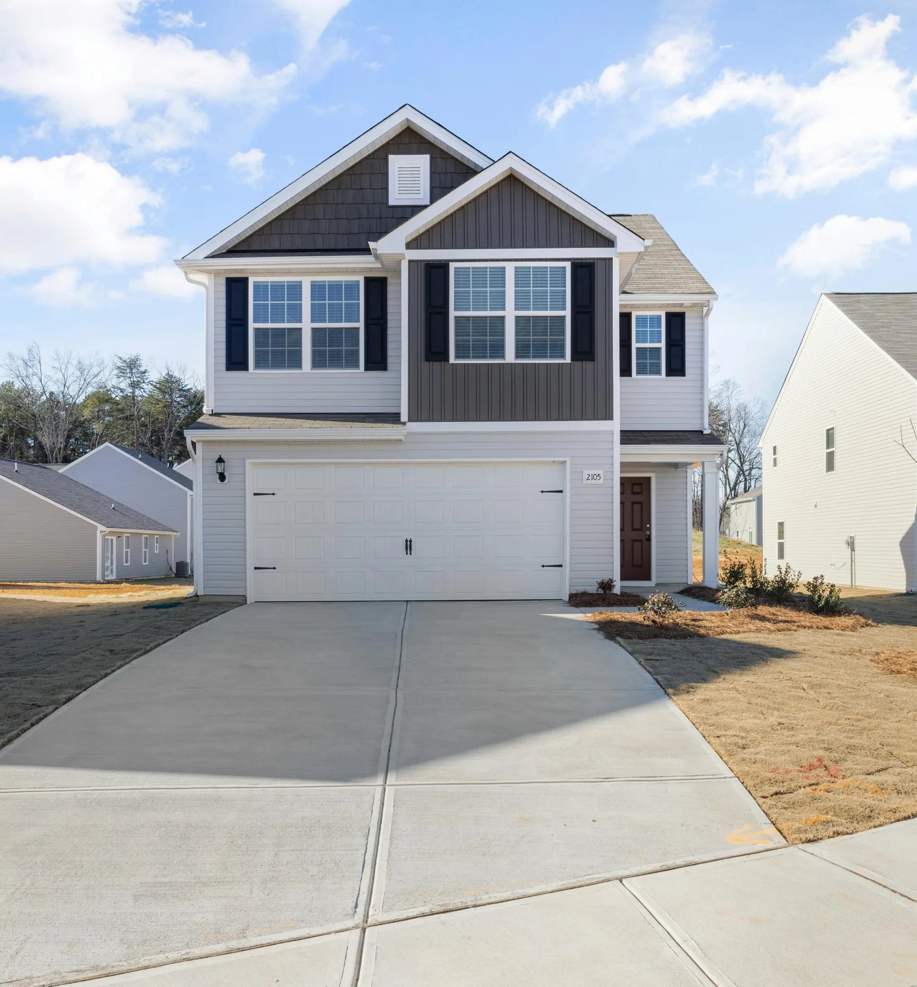 new concrete driveway at a grey new-build Boston home