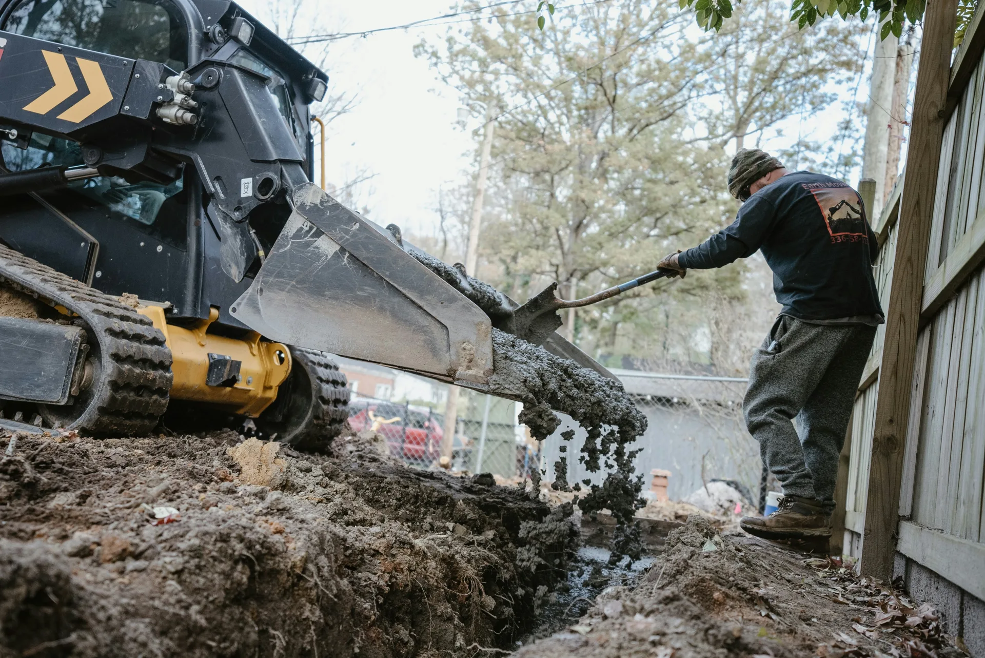 concrete foundation footing pour with a skid steer at a Boston site
