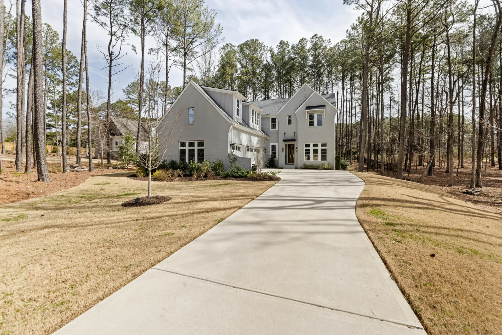 long curving concrete driveway through pines near Brookline