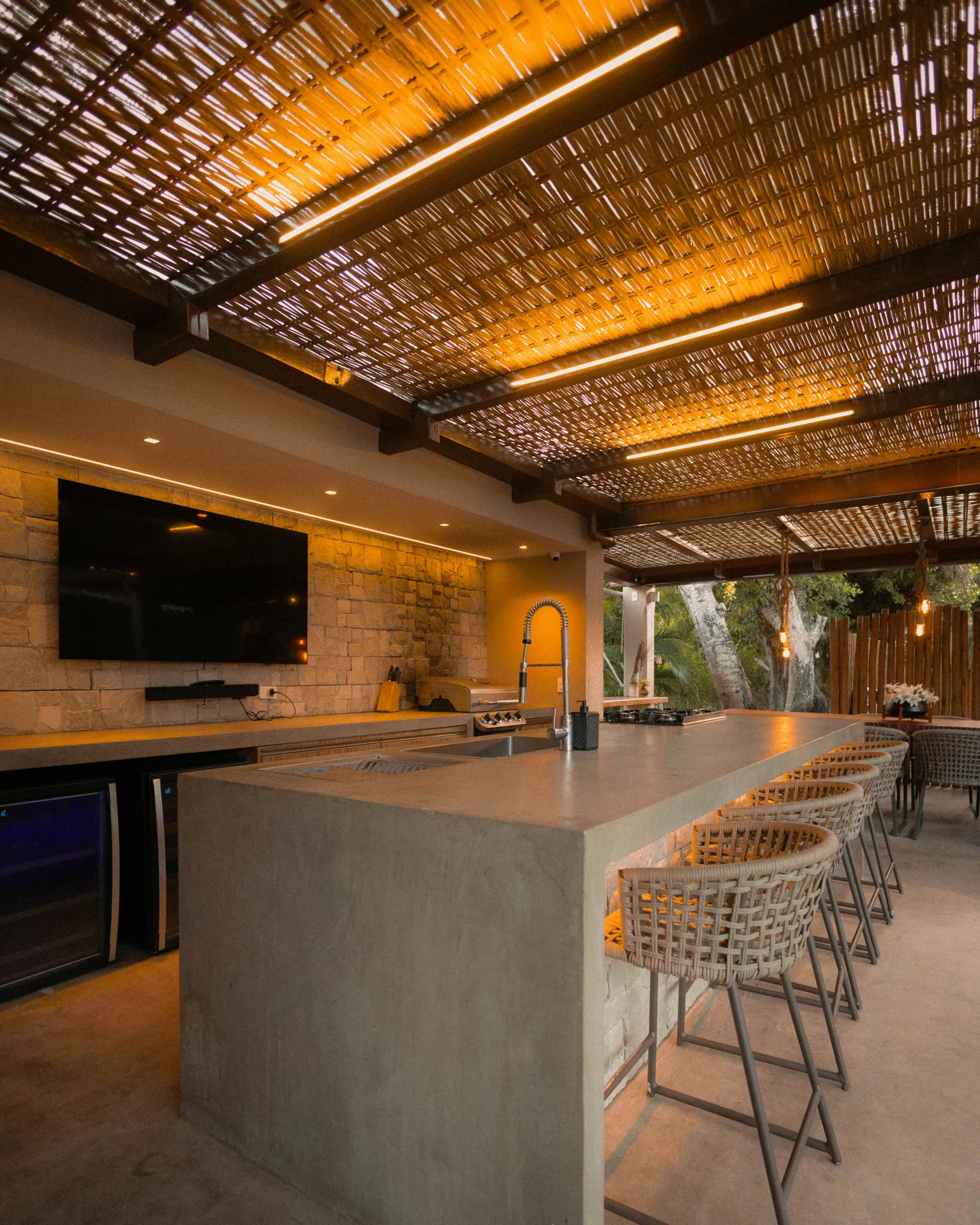 concrete outdoor kitchen bar under a pergola at a Boston home